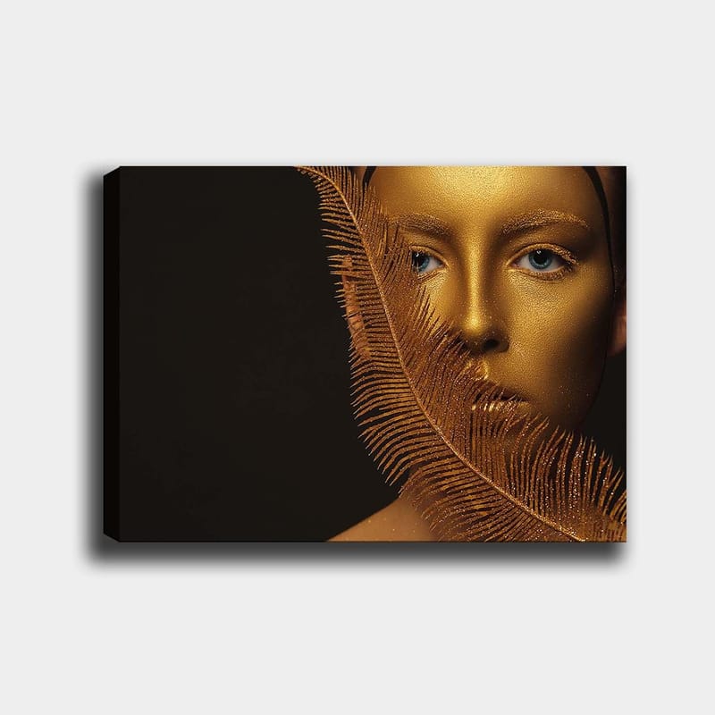 Canvastavla 70x100 cm - Ansiktsporträtt med en gyllene yta och blå ögon, omgiven av en dekorativ fjäderliknande struktur - Guld / Blå - Inredning - Tavlor & posters - Canvastavla