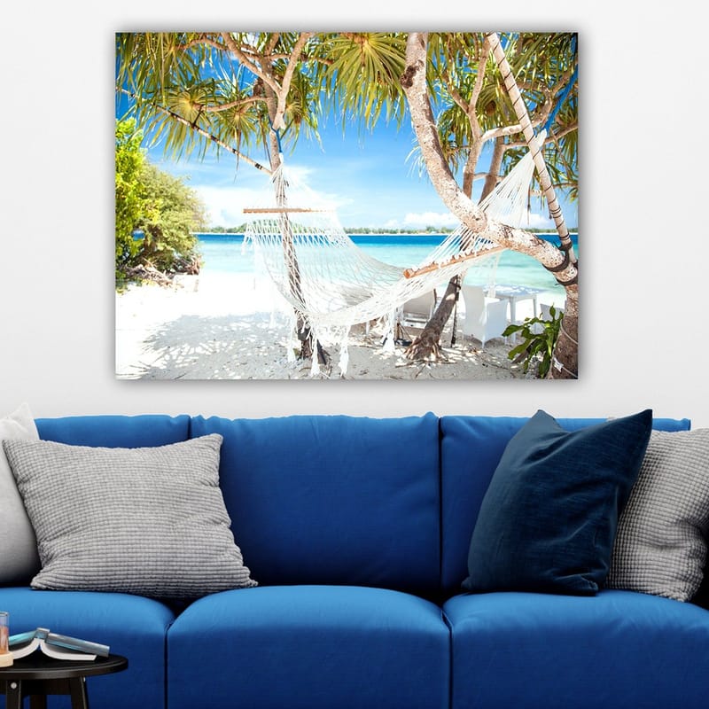 Canvastavla 70x100 cm - Avkopplande hängmatta mellan palmer vid en strand med turkost vatten och klarblå himmel - Vit / Blå / Grön - Inredning - Tavlor & posters - Canvastavla