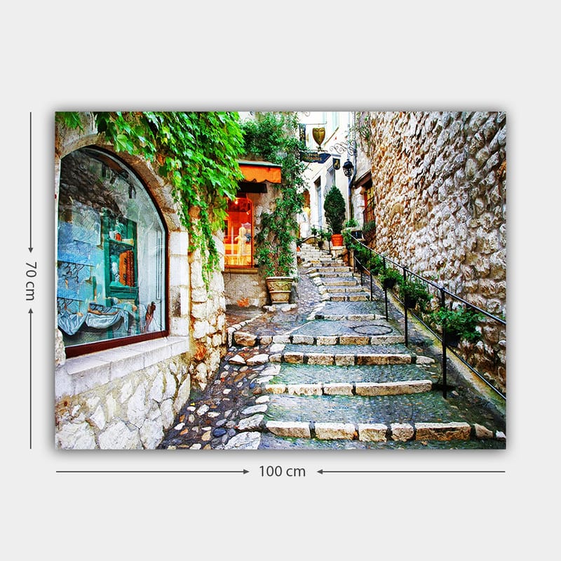 Canvastavla 70x100 cm - Charmig gränd med stenar och grönska som leder uppåt, omgiven av historiska byggnader - Grön / Beige / Orange - Inredning - Tavlor & posters - Canvastavla