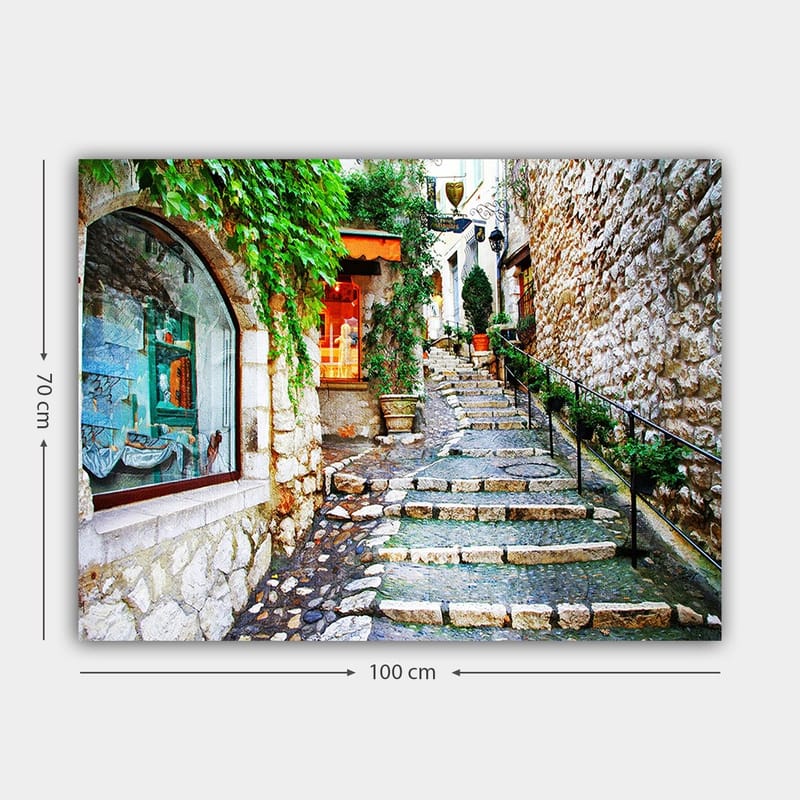 Canvastavla 70x100 cm - Charmig gränd med stenar och grönska som leder uppåt, omgiven av historiska byggnader - Grön / Beige / Orange - Inredning - Tavlor & posters - Canvastavla