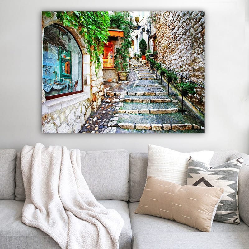Canvastavla 70x100 cm - Charmig gränd med stenar och grönska som leder uppåt, omgiven av historiska byggnader - Grön / Beige / Orange - Inredning - Tavlor & posters - Canvastavla