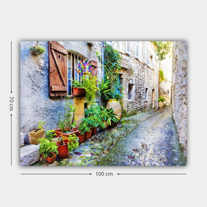 Canvastavla 70x100 cm - Charmig gränd med stenhus och blomsterkrukor som skapar en livlig atmosfär - Grön / Blå / Beige - Inredning - Tavlor & posters - Canvastavla