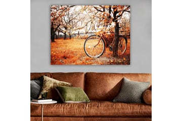 Canvastavla 70x100 cm - Cykel lutad mot ett träd i en höstig landskap med orangea och gula löv - Orange / Gul / Brun - Inredning - Tavlor & posters - Canvastavla