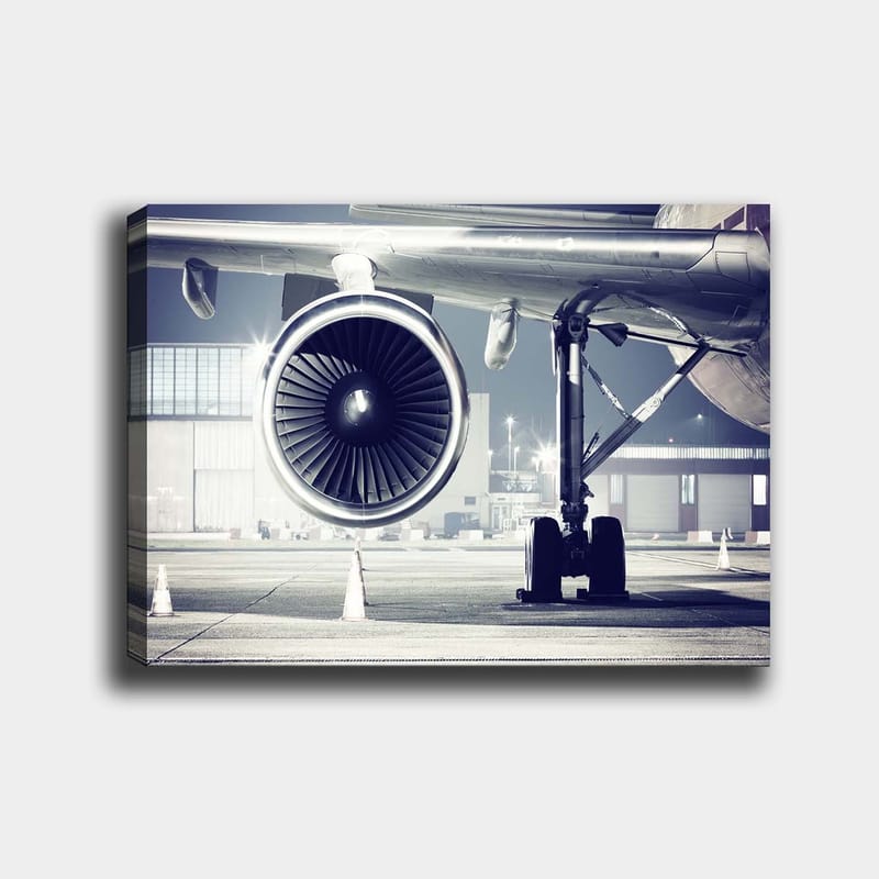 Canvastavla 70x100 cm - Detaljerad vy av ett flygplansmotor och dess underrede på en flygplats, Grå / Svart / Silver