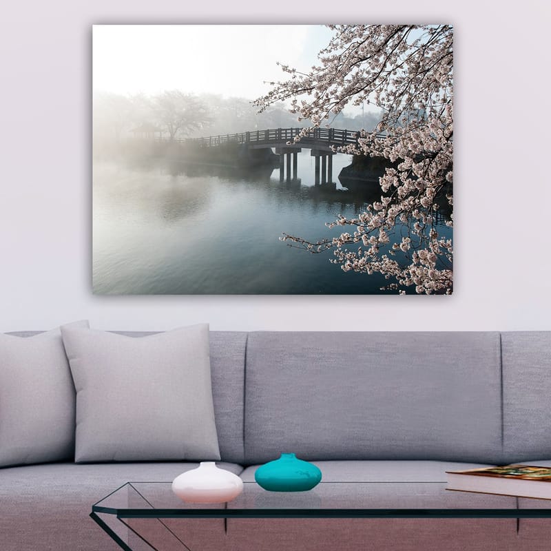 Canvastavla 70x100 cm - Dimmig scen med en bro som sträcker sig över en stilla sjö, omgiven av körsbärsträd i blom - Ljusrosa / Blå / Grå - Inredning - Tavlor & posters - Canvastavla
