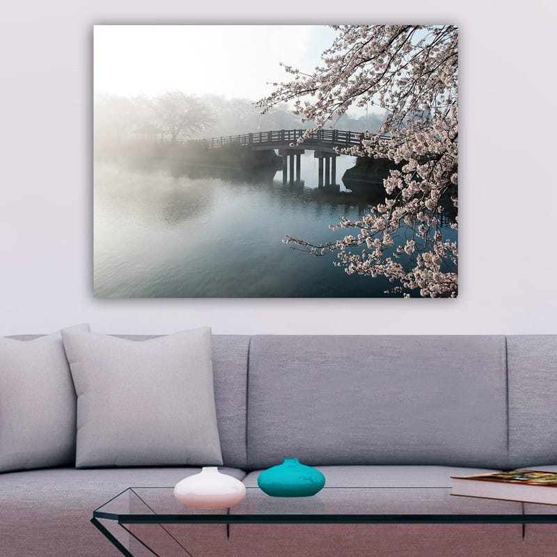 Canvastavla 70x100 cm - Dimmig scen med en bro som sträcker sig över en stilla sjö, omgiven av körsbärsträd i blom - Ljusrosa / Blå / Grå - Inredning - Tavlor & posters - Canvastavla