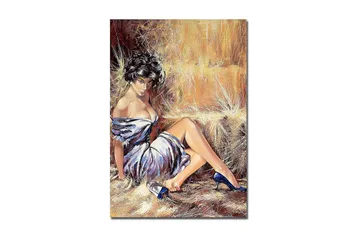 Canvastavla 70x100 cm - Elegant kvinna i en vit klänning med blå skor sitter avslappnat mot en halmbal - Vit / Blå / Beige - Inredning - Tavlor & posters - Canvastavla