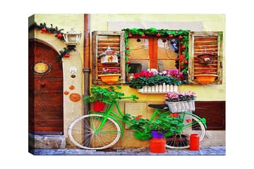 Canvastavla 70x100 cm - Färgglad cykel prydd med blommor och krukor framför en charmig vägg med fönster och dekorationer - Grön / Rosa / Orange - Inredning - Tavlor & posters - Canvastavla