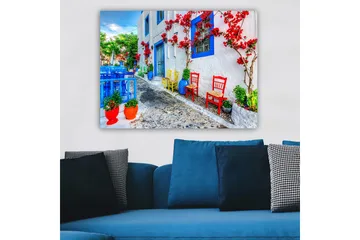 Canvastavla 70x100 cm - Färgglad gata med blommor och stolar i olika färger som skapar en livlig atmosfär - Blå / Röd / Grön - Inredning - Tavlor & posters - Canvastavla