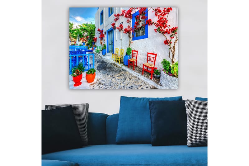 Canvastavla 70x100 cm - Färgglad gata med blommor och stolar i olika färger som skapar en livlig atmosfär - Blå / Röd / Grön - Inredning - Tavlor & posters - Canvastavla