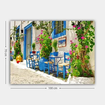 Canvastavla 70x100 cm - Färgglad och livlig gata med blå stolar och blomkrukor i en medelhavsmiljö - Blå / Grön / Rosa - Inredning - Tavlor & posters - Canvastavla