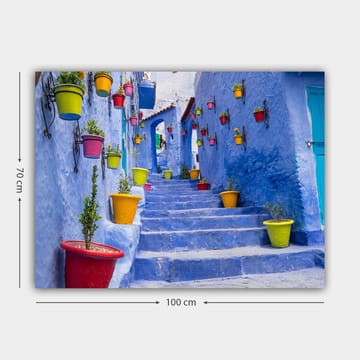 Canvastavla 70x100 cm - Färgglad trappa omgiven av blomkrukor i en pittoresk, blå stadsmiljö - Blå / Gul / Röd - Inredning - Tavlor & posters - Canvastavla