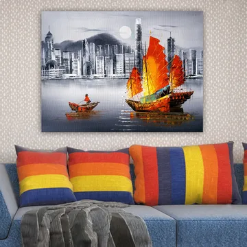 Canvastavla 70x100 cm - Färgstark segelbåt med röda segel på en spegelblanka vattenyta, omgiven av en modern stadsbild - Röd / Orange / Blå - Inredning - Tavlor & posters - Canvastavla