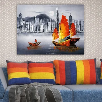 Canvastavla 70x100 cm - Färgstark segelbåt med röda segel på en spegelblanka vattenyta, omgiven av en modern stadsbild - Röd / Orange / Blå - Inredning - Tavlor & posters - Canvastavla