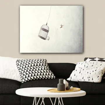 Canvastavla 70x100 cm - Fågelbur hänger i luften med en fågel som flyger i närheten - Grå / Svart / Vit - Inredning - Tavlor & posters - Canvastavla
