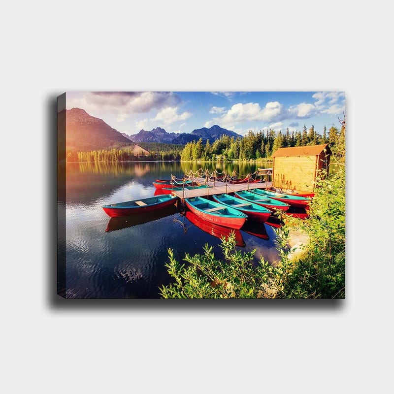 Canvastavla 70x100 cm - Flera färgglada båtar ligger vid en spegelblanka sjö omgiven av grönskande träd och berg - Röd / Turkos / Grön - Inredning - Tavlor & posters - Canvastavla