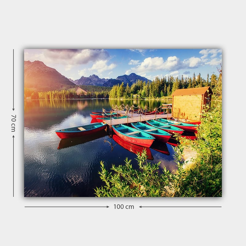 Canvastavla 70x100 cm - Flera färgglada båtar ligger vid en spegelblanka sjö omgiven av grönskande träd och berg - Röd / Turkos / Grön - Inredning - Tavlor & posters - Canvastavla