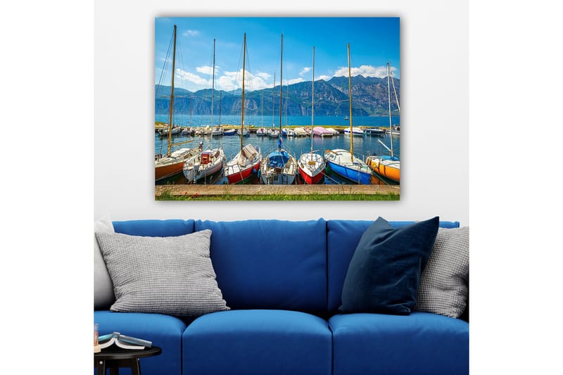 Canvastavla 70x100 cm - Flera färgglada segelbåtar vid en hamn med berg i bakgrunden, Blå / Röd / Orange