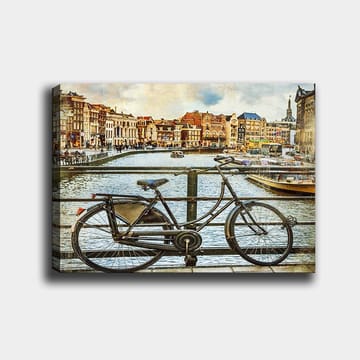 Canvastavla 70x100 cm - Gammal cykel som står lutad mot en räcke vid en kanal med pittoreska byggnader i bakgrunden - Svart / Grå / Brun - Inredning - Tavlor & posters - Canvastavla