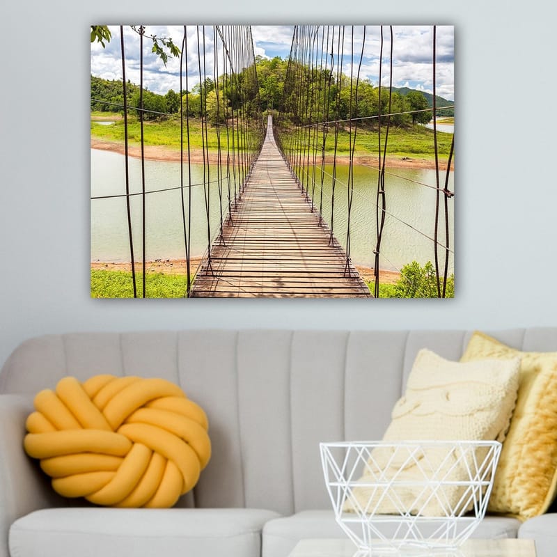 Canvastavla 70x100 cm - Hängbro som sträcker sig över en stilla sjö, omgiven av grönskande landskap - Grön / Brun / Blå - Inredning - Tavlor & posters - Canvastavla