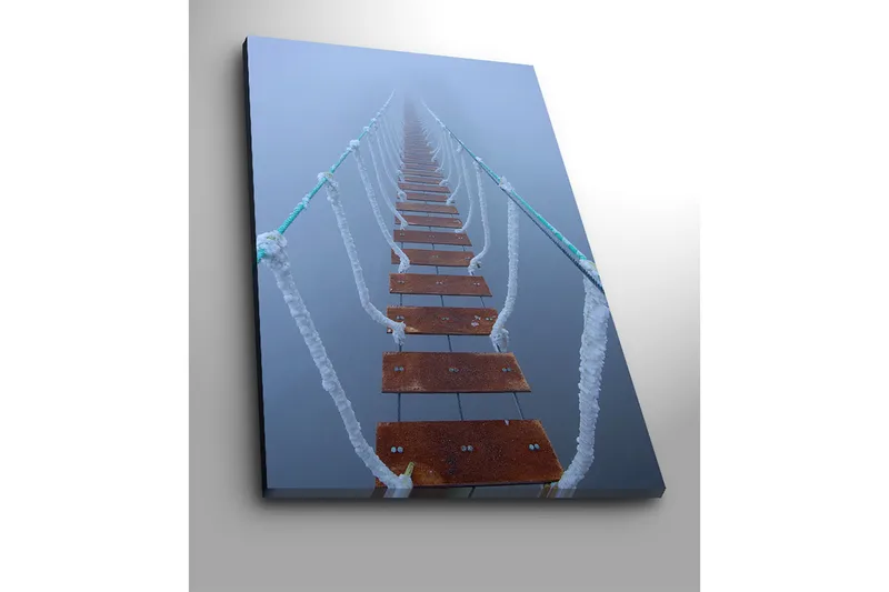 Canvastavla 70x100 cm - Hängbro som sträcker sig genom dimma, vilket skapar en mystisk och avlägsen känsla - Mörkbrun / Vit / Ljusblå - Inredning - Tavlor & posters - Canvastavla