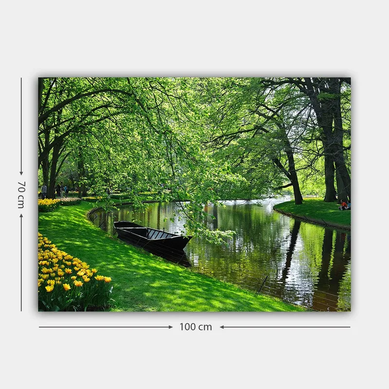 Canvastavla 70x100 cm - Idyllisk sjöscen med en båt som ligger stilla vid en grönskande strand omgiven av träd och blommor - Grön / Svart / Gul - Inredning - Tavlor & posters - Canvastavla
