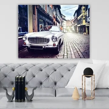 Canvastavla 70x100 cm - Klassisk vit bil parkerad på en charmig, gammaldags gata med historiska byggnader - Vit / Svart / Grå - Inredning - Tavlor & posters - Canvastavla