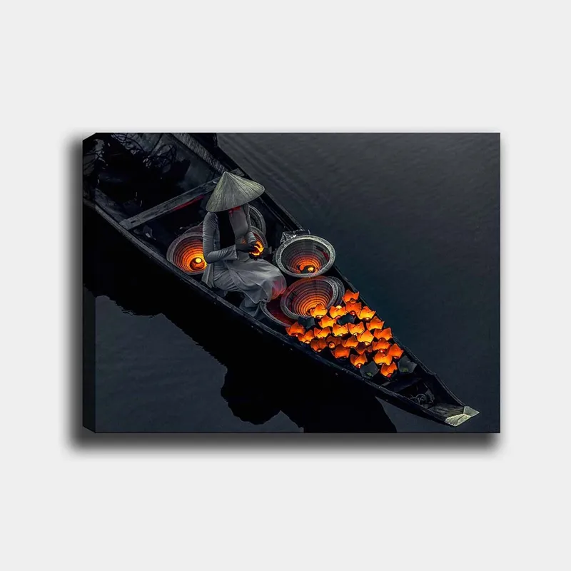 Canvastavla 70x100 cm - Kvinna i en båt som omger sig med lysande orange fiskar och traditionella korgar, Orange / Svart / Grå