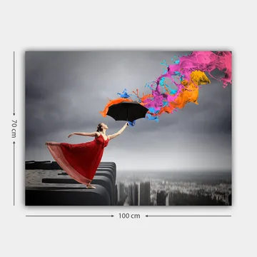 Canvastavla 70x100 cm - Kvinna i röd klänning står på en kant och håller ett paraply, medan färgglada färgstrålar sprutar ut från det - Röd / Svart / Orange - Inredning - Tavlor & posters - Canvastavla