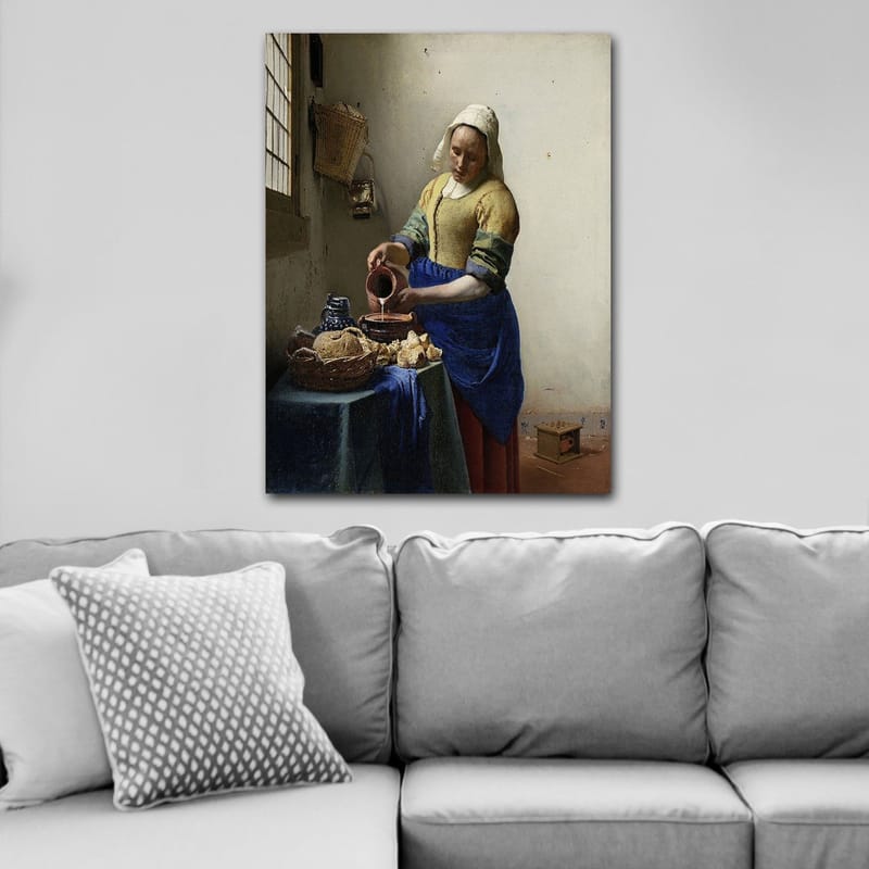 Canvastavla 70x100 cm - Kvinna som häller mjölk i en skål i ett ljust kök - Blå / Gul / Brun - Inredning - Tavlor & posters - Canvastavla