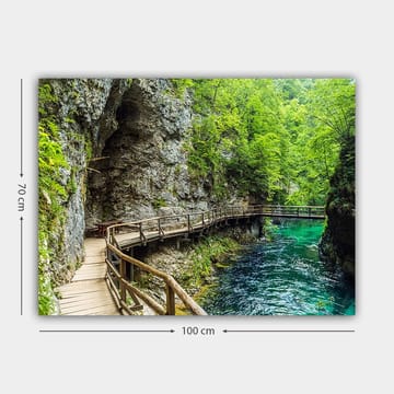 Canvastavla 70x100 cm - Naturskön vy av en träbro som slingrar sig genom en grönskande ravin vid en klar, turkos flod - Grön / Turkos / Grå - Inredning - Tavlor & posters - Canvastavla