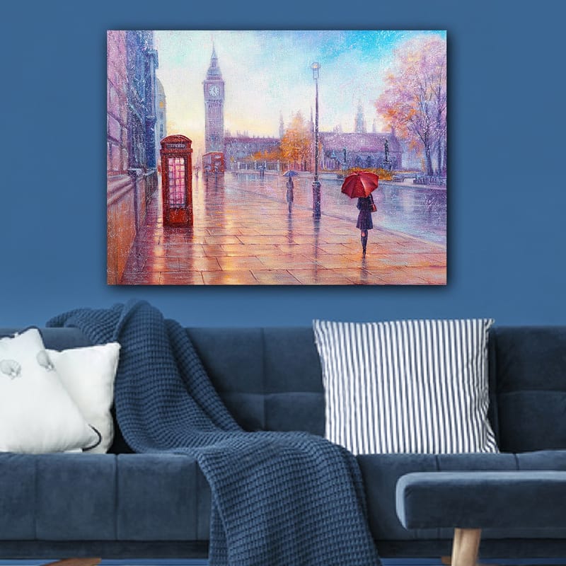 Canvastavla 70x100 cm - Regnig stadsbild med en röd telefonkiosk och en person med röd paraply som promenerar längs en blöt gata - Röd / Blå / Orange - Inredning - Tavlor & posters - Canvastavla