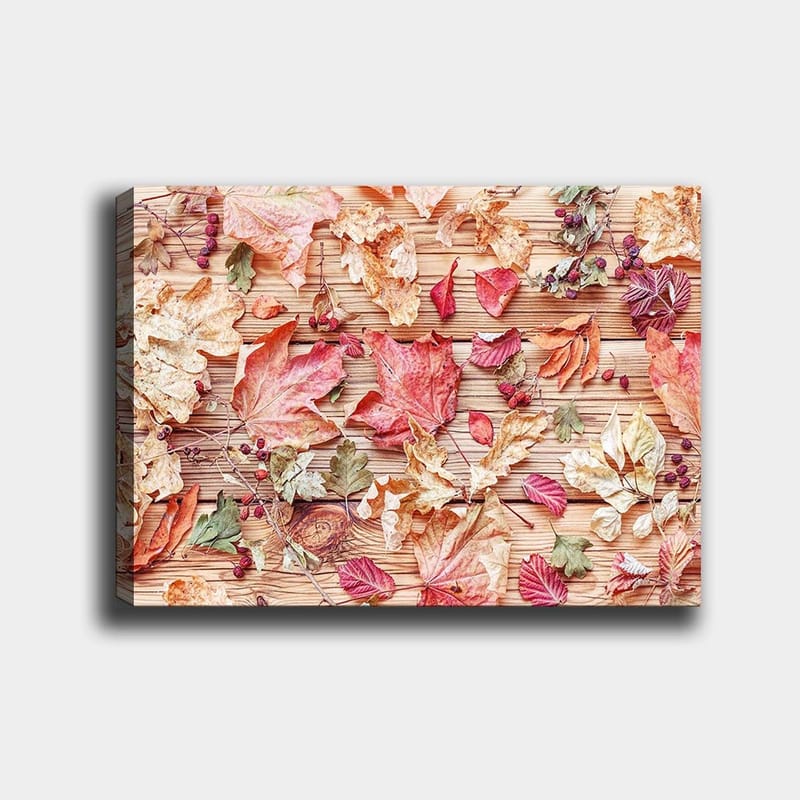 Canvastavla 70x100 cm - Samling av höstlöv i olika färger som ligger på en träyta - Röd / Gul / Grön - Inredning - Tavlor & posters - Canvastavla