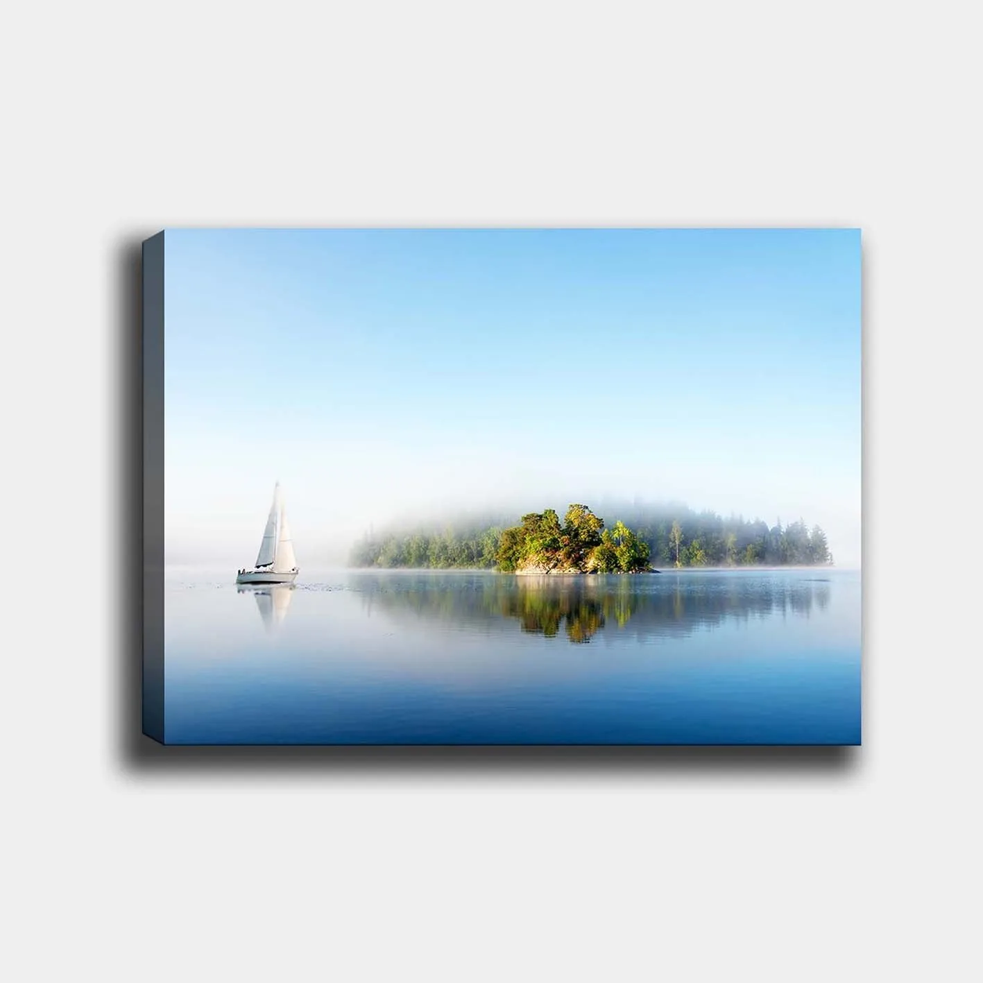 Canvastavla 70x100 cm - Segelbåt glider fram över en spegelblanka sjö med en dimmig ö i bakgrunden - Blå / Grön / Vit
