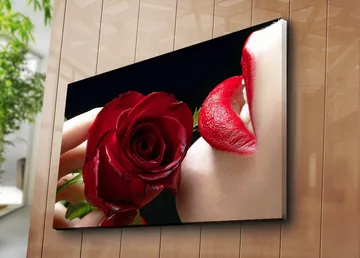 Canvastavla 70x100 cm - Sensuell närbild av en ros som hålls nära en läpp med röd läppstift - Röd / Grön - Inredning - Tavlor & posters - Canvastavla