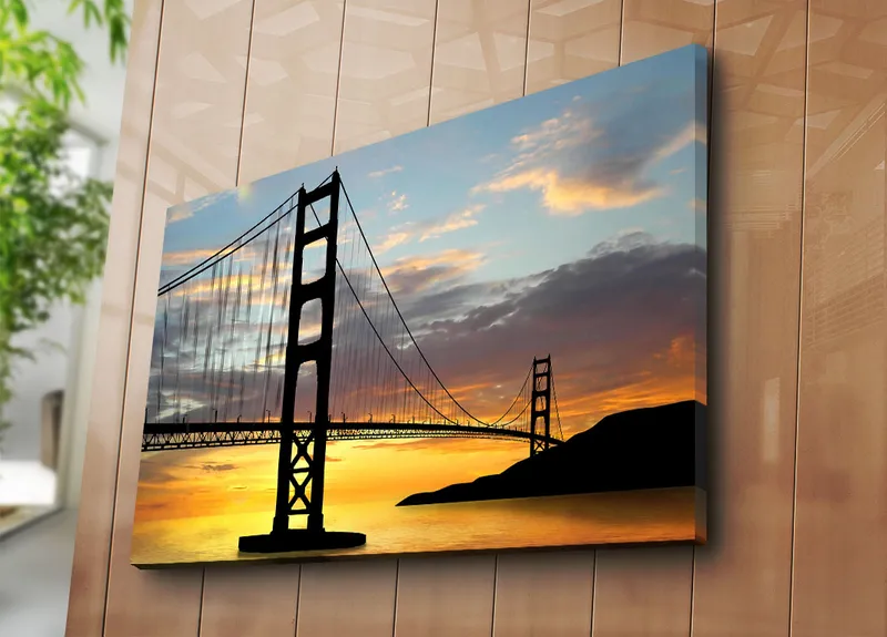 Canvastavla 70x100 cm - Silhuett av en bro mot en färgsprakande solnedgång - Orange / Svart / Blå - Inredning - Tavlor & posters - Canvastavla