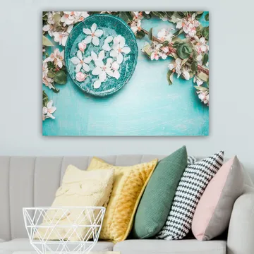 Canvastavla 70x100 cm - Skål med blommor omgiven av grönskande kvistar och blommor på en ljusblå bakgrund - Turkos / Vit / Rosa - Inredning - Tavlor & posters - Canvastavla