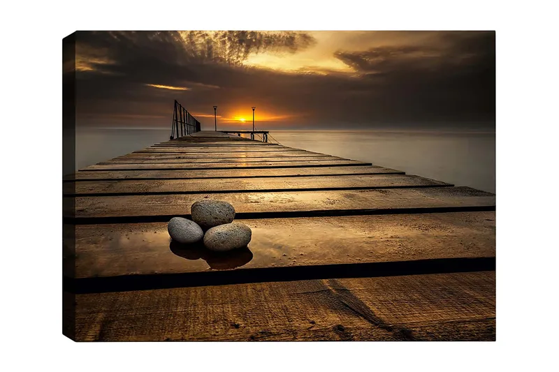 Canvastavla 70x100 cm - Stilla brygga vid solnedgången med stenar i förgrunden, Guld / Brunt / Grått