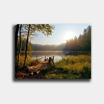 Canvastavla 70x100 cm - Stilla sjö med en träbro omgiven av grönskande träd och morgonsolens strålar - Grön / Brun / Gul - Inredning - Tavlor & posters - Canvastavla