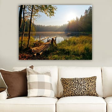 Canvastavla 70x100 cm - Stilla sjö med en träbro omgiven av grönskande träd och morgonsolens strålar - Grön / Brun / Gul - Inredning - Tavlor & posters - Canvastavla