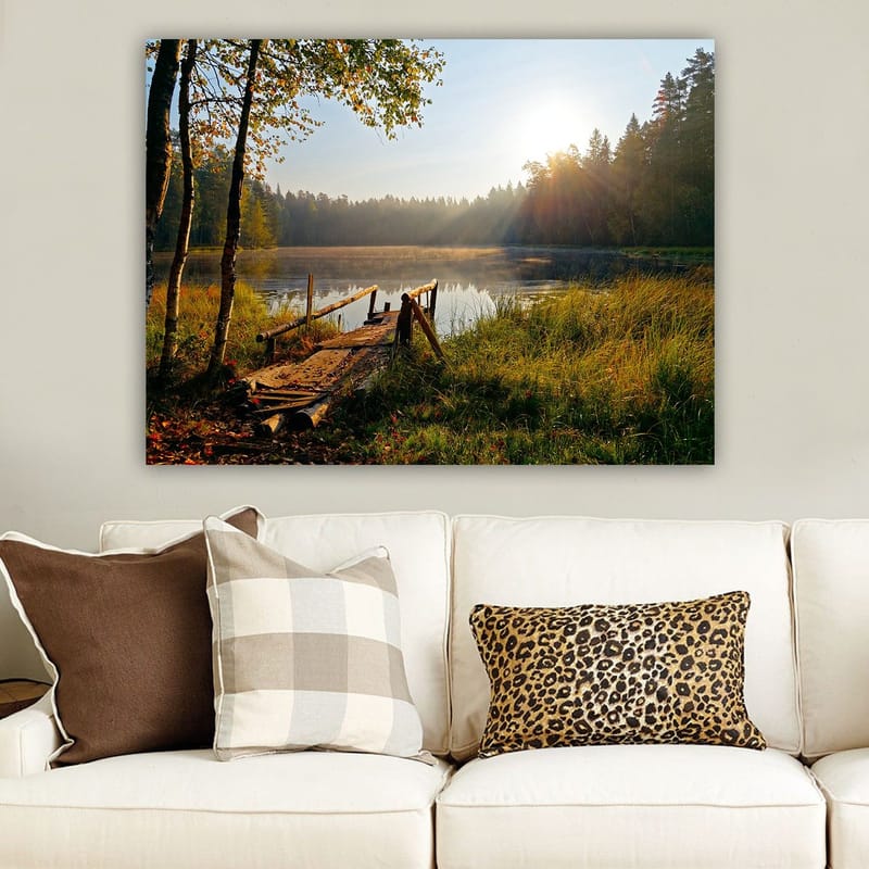 Canvastavla 70x100 cm - Stilla sjö med en träbro omgiven av grönskande träd och morgonsolens strålar - Grön / Brun / Gul - Inredning - Tavlor & posters - Canvastavla