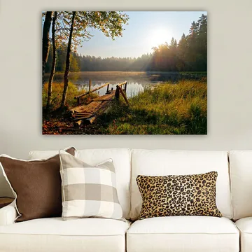 Canvastavla 70x100 cm - Stilla sjö med en träbro omgiven av grönskande träd och morgonsolens strålar - Grön / Brun / Gul - Inredning - Tavlor & posters - Canvastavla