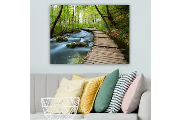 Canvastavla 70x100 cm - Stilla skogsstig som slingrar sig över en porlande bäck omgiven av grönskande träd och växtlighet - Grön / Brun / Blå - Inredning - Tavlor & posters - Canvastavla