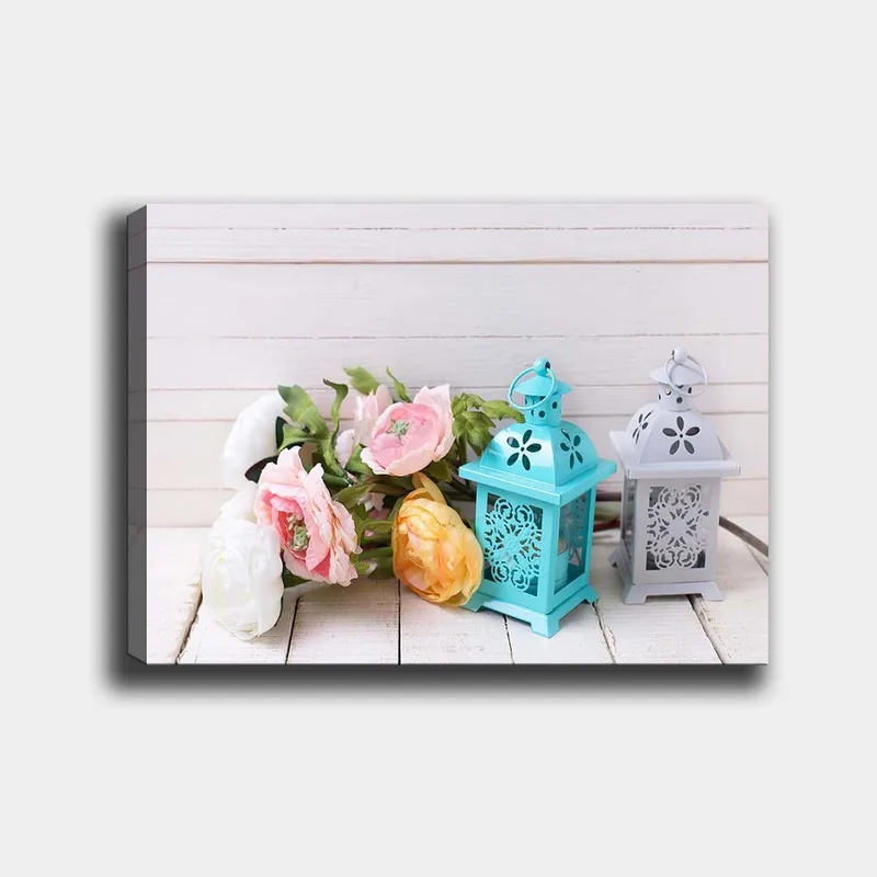 Canvastavla 70x100 cm - Stillsam komposition av blommor och lanternor i pastellfärger, Ljusblå / Rosa / Gul