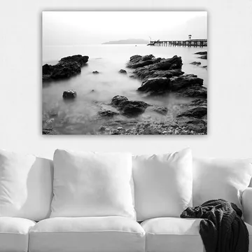 Canvastavla 70x100 cm - Stillsam kustlandskap med klippor och en brygga i fjärran - Svart / Vitt / Grått - Inredning - Tavlor & posters - Canvastavla