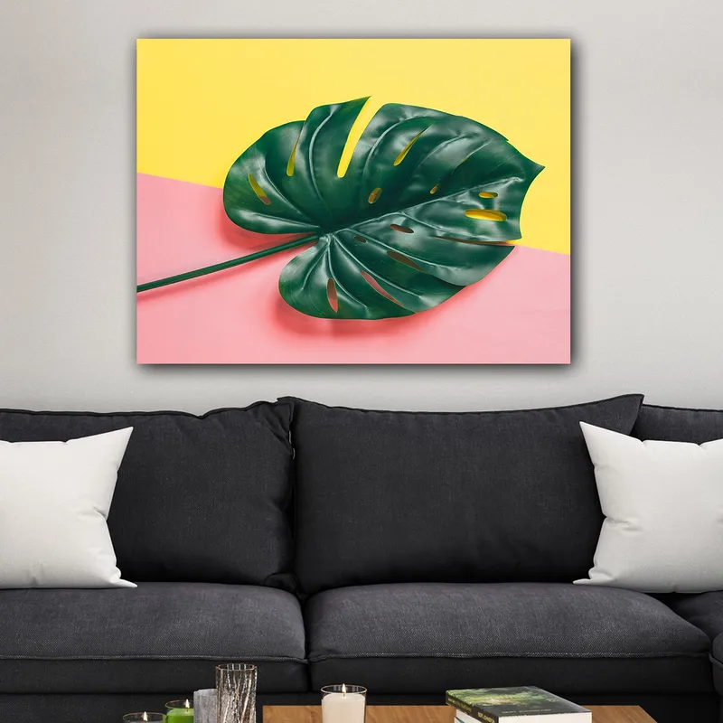 Canvastavla 70x100 cm - Stor, grön monstera-blad mot en färgglad bakgrund av gul och rosa - Grön / Gul / Rosa - Inredning - Tavlor & posters - Canvastavla