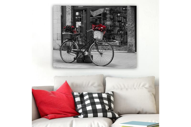 Canvastavla 70x100 cm - Svart cykel med blommor i korgar på en gata, Röd / Svart / Grå