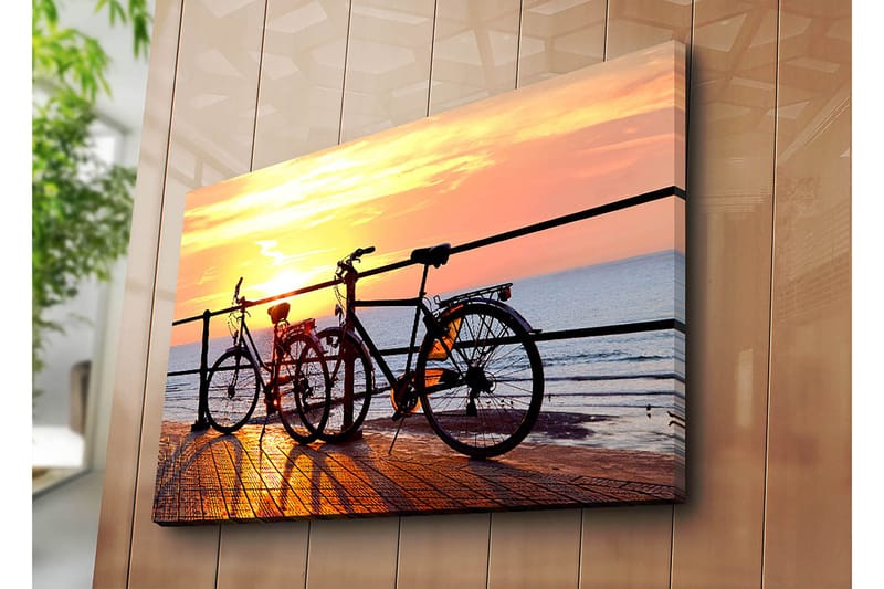 Canvastavla 70x100 cm - Två cyklar som står på en brygga vid solnedgången över havet - Orange / Svart / Gult - Inredning - Tavlor & posters - Canvastavla