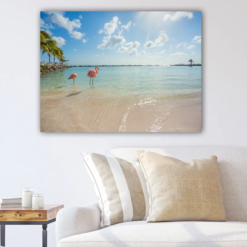 Canvastavla 70x100 cm - Två flamingos som står vid strandkanten i ett klart, turkost hav, Rosa / Turkos / Beige
