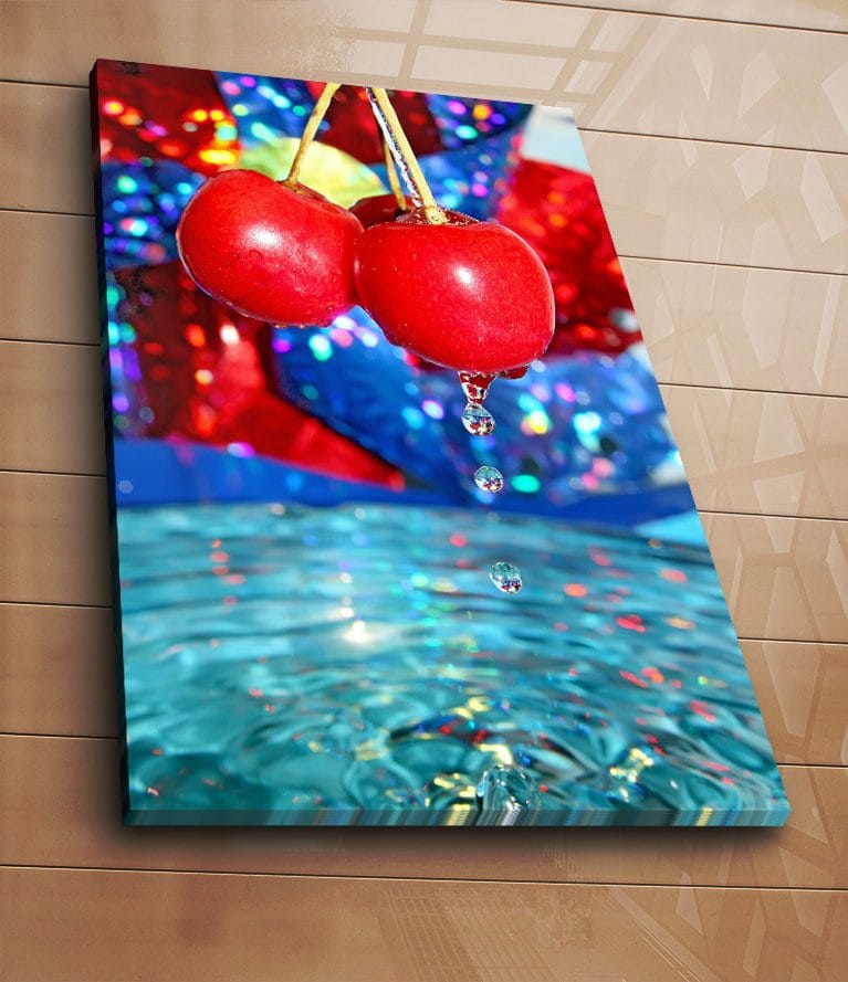 Canvastavla 70x100 cm - Två röda körsbär hänger över en vattenyta med droppar som faller ner - Röd / Blå / Turkos - Inredning - Tavlor & posters - Canvastavla